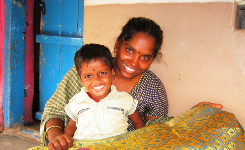 Elakiya with her son holding a Saree on which she has put the stones
