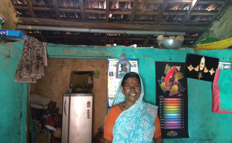 Chandravva in of her home with the newly constructed roof